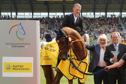 Foto: Dem Sieger gratulieren der langjährige Werbepartner der AachenMünchener, Mario Adorf, und Michael Westkamp, Vorstandsvorsitzender der AachenMünchener. - Fotograf: CHIO Aachen/MichaelStrauch