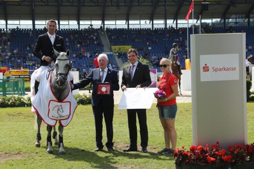 Foto: Dem Sieger gratulieren v.l. Hans Kauhsen, Aufsichtsratsmitglied des Aachen-Laurensberger Rennvereins und Norbert Laufs, stellvertretender Vorstandsvorsitzender der Sparkasse Aachen. - Fotograf: Aachen 2015/ Michael Strauch