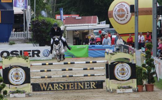 Foto: Carsten-Otto Nagel lässt das Warsteiner Hindernis mit Corradina fehlerfrei hinter sich. - Fotograf: Marie Scharffenorth