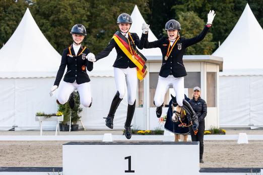 Foto: Fröhliches Trio auf dem DJM-Podest - Gold für Rose Oatley (mi.), Silber für Julie Sofie Schmitz-Heinen (li.) und Bronze für Lilly Marie Collin - Fotograf: J. Fellner