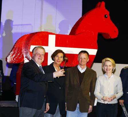 Foto: Versteigerung des LEGO-Pferdes: V.l. Auktionator Uwe Heckmann, Gudrun Bauer, Uwe Schmitz und Bundesverteidigungsministerin Ursula von der Leyen.