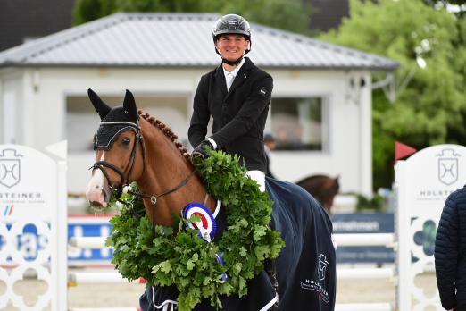 Foto: Die strahlenden Holsteiner Landeschampions der fünfjährigen Springpferde: Chacfire v. Chacfly und Tjade Carstensen - Fotograf: Janne Bugtrup