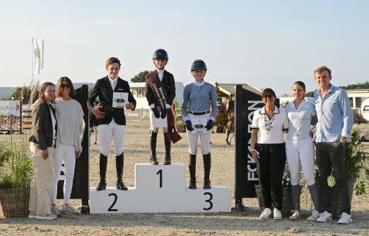 Foto: Sie war die Kleinste und die Nummer eins bei den Children: Janne Neumann und ie Platzierten Joep Schaap und Svea Wagner mit Gratulanten in der Siegerehrung - Fotograf: Frederike Markett