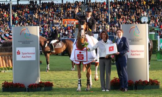 Das Foto zeigt den Sieger im Sparkassen-Youngsters-Cup, Richard Vogel, gemeinsam mit dem Vorstandsvorsitzenden der Sparkasse Aachen Norbert Laufs und ALRV-Präsidentin Stefanie Peters. - Fotograf: Foto: CHIO Aachen/Michael Strauch