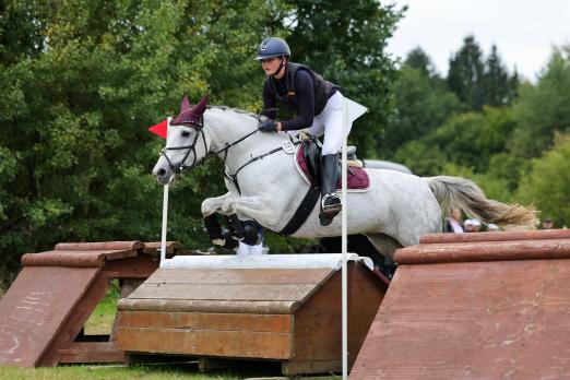 Foto: Nach dem Gelände führt Marlene Mühlenbeck (RV Rot-Weiss Sollerup-Hünningen e.V.) im Sattel der Schimmelponystute Sweet Snail v. Joe Cool die Landesmeisterschaft Vielseitigkeit an - Fotograf: Photo Rocket