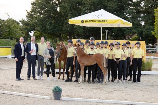 Foto: Preisspitze Daisy Deluxe mit Auktionsleiter Wilken Treu, Auktionator Bernd Hickert, Züchter Michael Niethammer und den Hannoveraner Jungzüchtern, die die Fohlen perfekt vorgeführt haben - Fotograf: Hannoveraner Verband