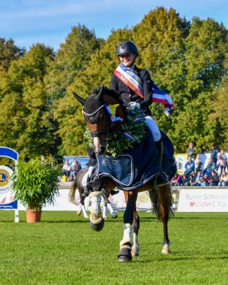 Foto: Im vergangenen Jahr noch Eignungschampion, sicherte sich Proud Day Max v. Dreidimensional I AT NRW heute unter Jule Pauls (RSG Syltkuhlen e.V.) die Schärpe des Dressurpony-Champions 2025 - Fotograf: RathmannVerlag/Malina Blunck