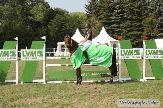 Foto: Strahlende Gesichter gab es in Ahrensfelde: Melina Demir freute sich über den Sieg in der Stilspringprüfung Kl. L und löste damit das Ticket für das große Finale des LVM Cups in Neumünster - Fotograf: Tierfotografie Huber