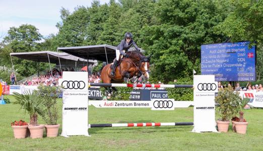 Foto: Mit Riesensätzen vor schöner Kulisse zum Sieg im Großen Preis von Bremen - Dänemarks Zascha Nygaard Lill mit Nikita du Roton - Fotograf: ACP Andreas Pantel