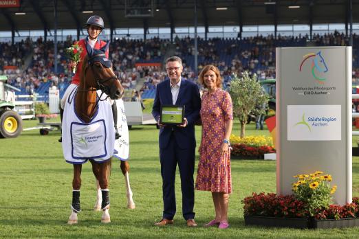 Foto: Das Foto zeigt die Siegerin im Preis der Städteregion beim CHIO Aachen 2025, Laura Kraut aus den USA auf Emeraldo gemeinsam mit StädteRegionsrat Dr. Tim Grüttemeier und ALRV-Präsidentin Stefanie Peters - Fotograf: CHIO Aachen/Andreas Steindl Foto: Das Foto zeigt die Siegerin im Preis der Städteregion beim CHIO Aachen 2025, Laura Kraut aus den USA auf Emeraldo gemeinsam mit StädteRegionsrat Dr. Tim Grüttemeier und ALRV-Präsidentin Stefanie Peters - Fotograf: CHIO Aachen/Andreas Steindl