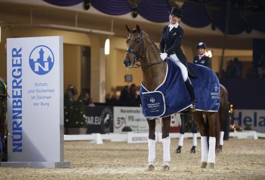 Foto: Strahlende Siegerin mit Vitalis im Finale des 25. Nürnberger Burg-Pokals: Isabel Freese pilotierte den Fuchshengst auf Platz eins mit 79,22 Prozent - Fotograf: Stefan Lafrentz