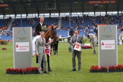 Foto: Sieger David Will gemeinsam mit Norbert Laufs (Vorstandsvorsitzender der Sparkasse Aachen) und ALRV-Aufsichtsratsmitglied Dr. Thomas Förl - Fotograf: CHIO Aachen/Michael Strauch