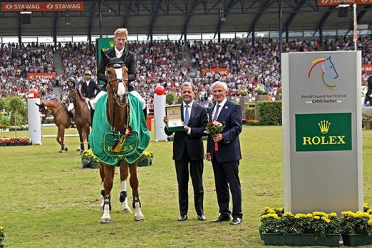 Foto: Dem Sieger Marcus Ehning gratulieren Rafael Rolli, Geschäftsführer Rolex Deutschland GmbH, und ALRV-Präsident Carl Meulenbergh - Fotograf: CHIO Aachen/ Michael Strauch 