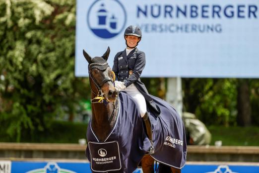 Foto: Straight Horse Ascenzione und Helen Langehanenberg mit breitem Siegerlächeln - Der NÜRNBERGER BURG-POKAL begeistert aktive Pferdesportler und Zuschauer gleichermaßen - Fotograf: Stefan Lafrentz