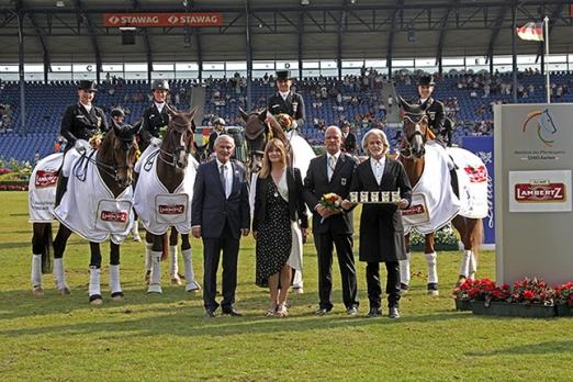 Foto: Dem siegreichen Team und Equipechef Klaus Röser (vorne, 2.v.r.) gratulieren v.l. ALRV-Präsident Carl Meulenbergh, Schauspielerin Nastassja Kinski, und Hermann Bühlbecker, Inhaber der Lambertz Gruppe - Fotograf: CHIO Aachen/ Michael Strauch 