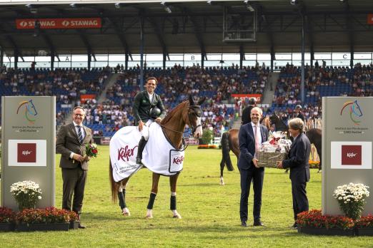 Foto: Das Foto zeigt Stephan de Freitas Barcha auf Chevaux Hex Lup Imperio Egipcio, das Siegerpaar im Feinkost Käfer-Preis, gemeinsam mit Michael Käfer und Ulli Minges (Vorstand der Feinkost Käfer GmbH und Geschäftsführer der Kaffee-Rösterei Minges) sowie ALRV-Aufsichtsratsmitglied - Fotograf: CHIO Aachen/Leonie Minten