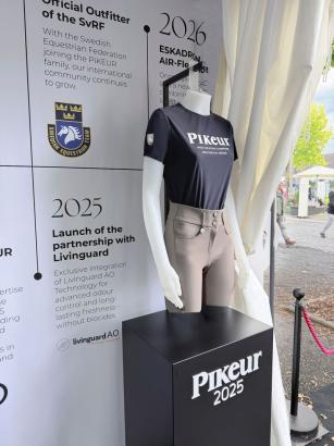 Foto: Pikeur-Fanshirt vor Infowand mit Details zur Partnerschaft mit Livinguard Technologies - Fotograf: Pikeur Foto: Pikeur-Fanshirt vor Infowand mit Details zur Partnerschaft mit Livinguard Technologies - Fotograf: Pikeur
